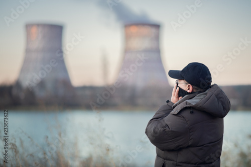 Adult man breathes polluted air by the river