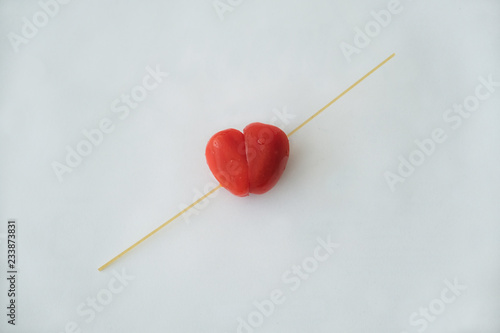 Red tomato heart on white background