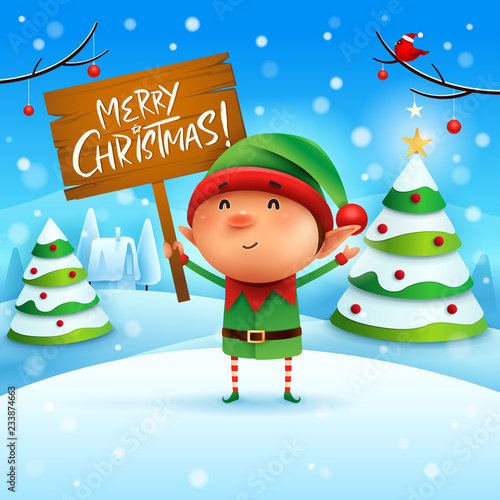 Merry Christmas! Little elf holds wooden board sign in Christmas snow scene winter landscape.