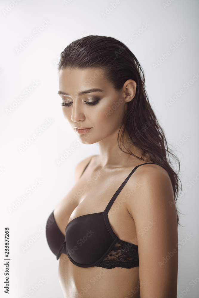 Sensual beautiful woman with wet long hair and perfect slim body posing in  studio wearing sexy lingerie. Elegant female model in sexy lingerie  standing on white gray background and sensually poses Photos