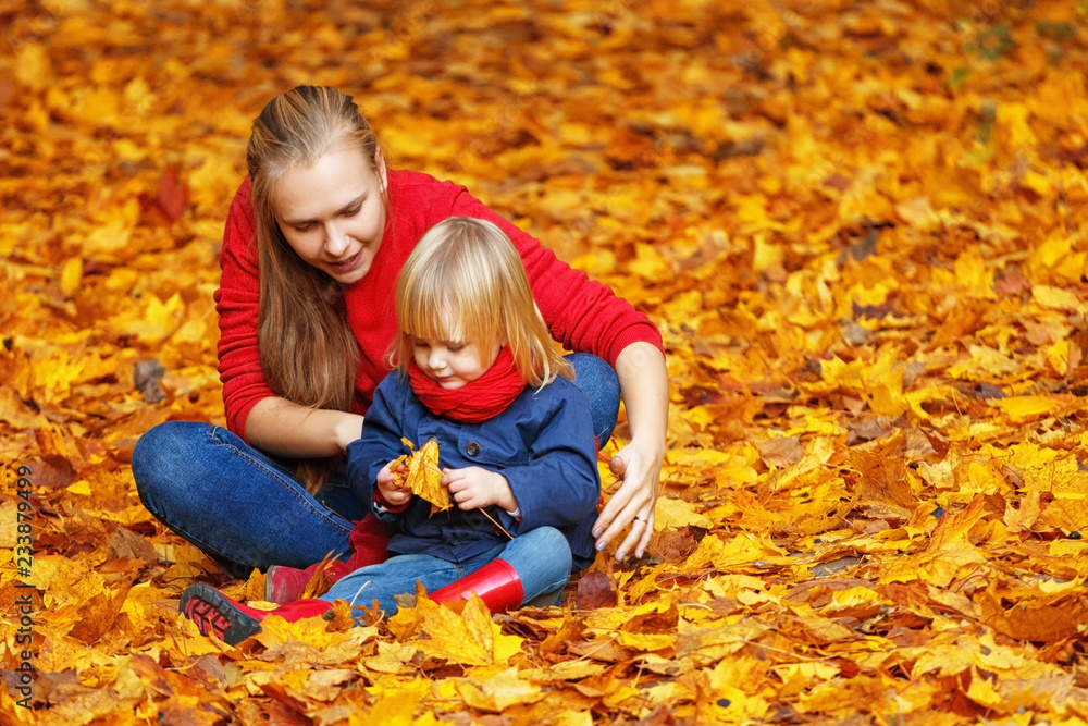 Happy autumn. A mother and daughter are playing and laughing in an autumn park. Happy autumn. A mother and daughter are playing and laughing in an autumn park.