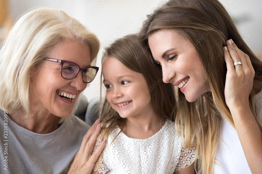 Smiling loving three generation of women concept laughing, grandmother, daughter and child girl bonding together, happy senior old grandma embracing kid granddaughter and grown mom having fun at home Smiling loving three generation of women concept laughing, grandmother, daughter and child girl bonding together, happy senior old grandma embracing kid granddaughter and grown mom having fun at home