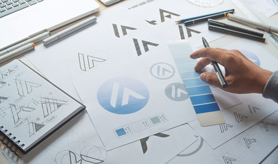 Graphic designer development process drawing sketch design creative Ideas draft Logo product trademark label brand artwork. Graphic designer studio Concept.