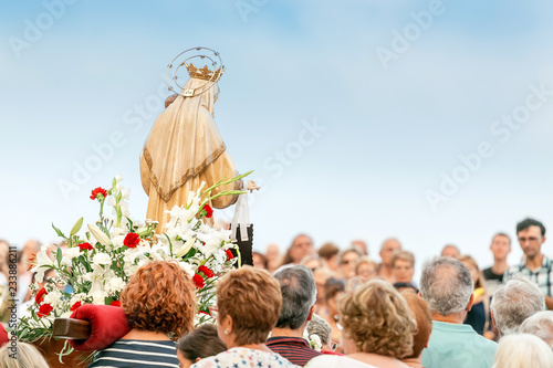 15 JULY 2018, TARRAGONA, SPAIN: People at celebration of religious holiday with Virgin Mary photo