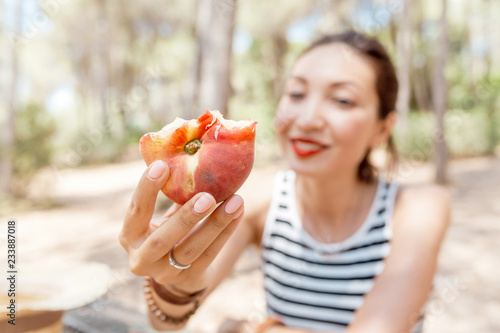 closeup beautiful girl eating peach, fruit snack concept