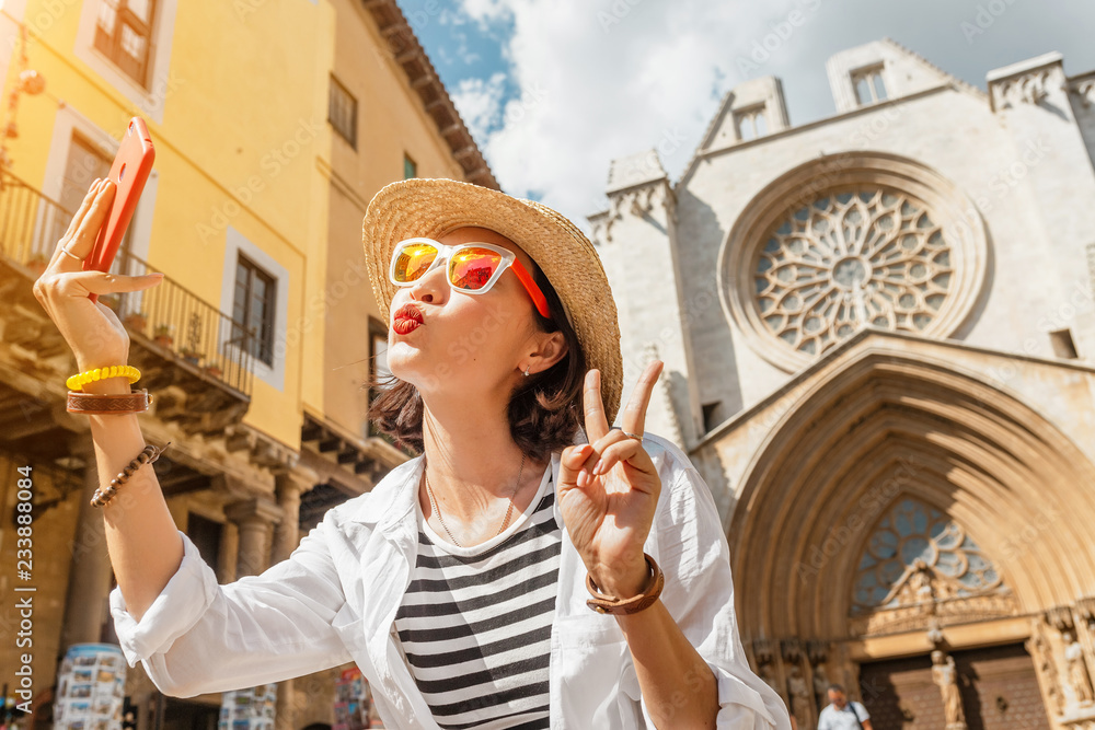 Happy young tourist woman taking selfie at the Tarragona Cathedral, One of most famous places in Catalonia, Spain