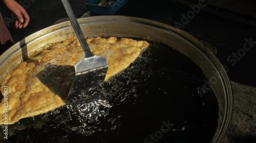 Process cooking national Buryat Mongolian dish cheburek. Big large xxxl 68cm heburek fry with cheese meat onions into cooking pot in oil. Fried flatbread piadina naan pita tortilla shelpek cheburek. photo