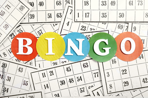 The word bingo made of wooden letters on bingo cards background.