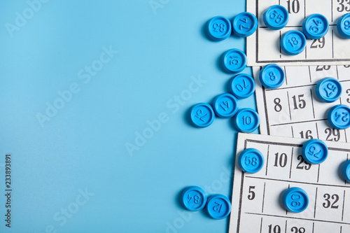 Bingo balls and cards on blue background with copy space. photo