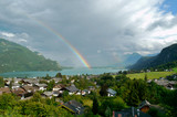 Sankt Gilgen, Salzkammergut, Austria. The Wolfgangsee Lake with the rainbow arch and the town in the foreground
