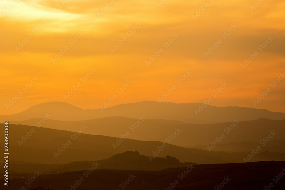 Rolling hills in silhouette at dawn