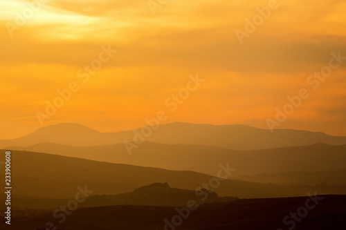 Rolling hills in silhouette at dawn