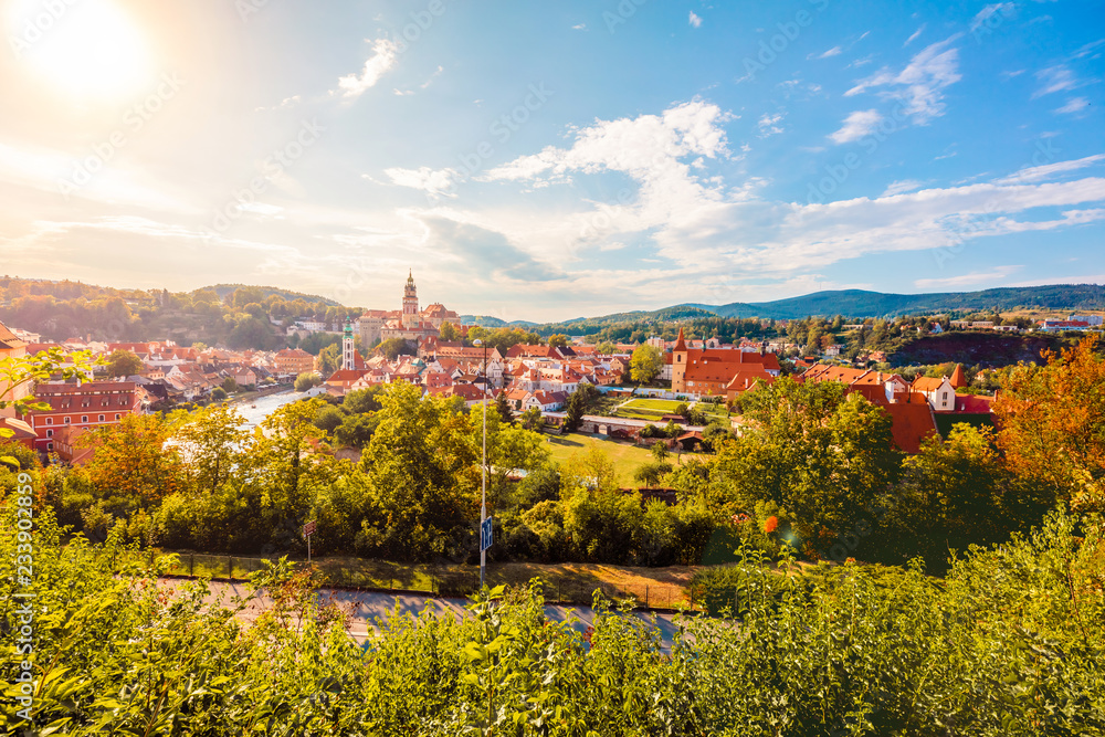 Cesky Krumlov, UNESCO, Czech Republic. Sunset aerial view of the old town pier architecture with red rooftops and houses.