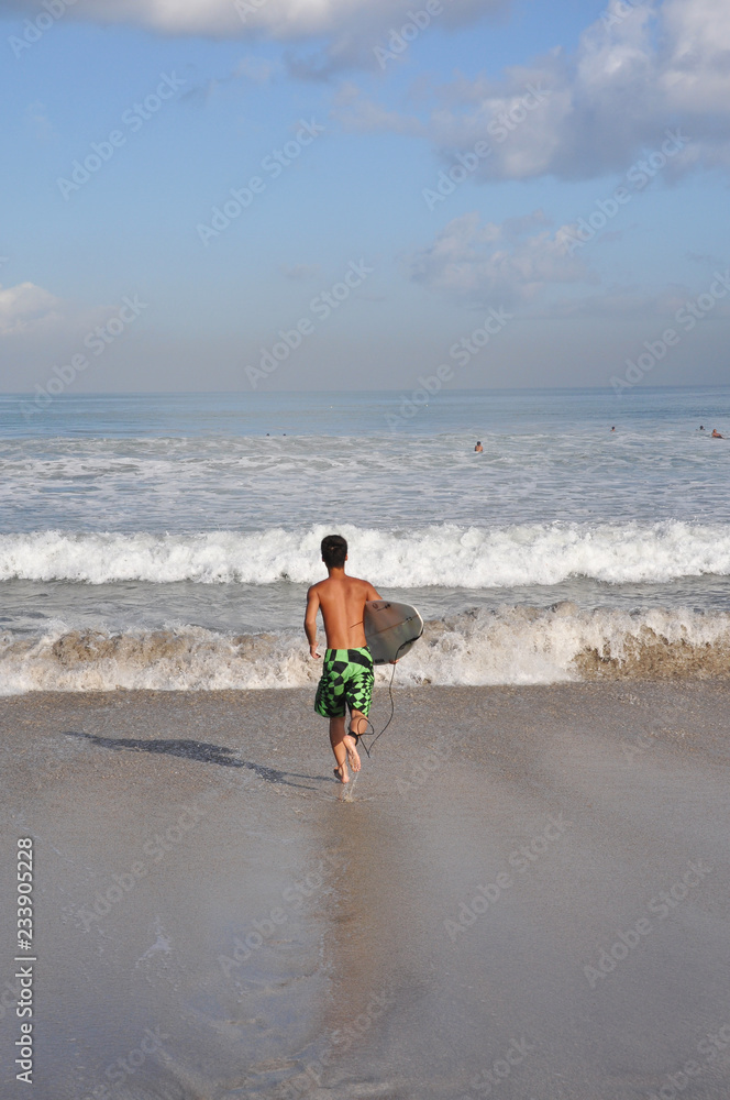 Surfer at Kuta Beach in Bali Surfer at Kuta Beach in Bali