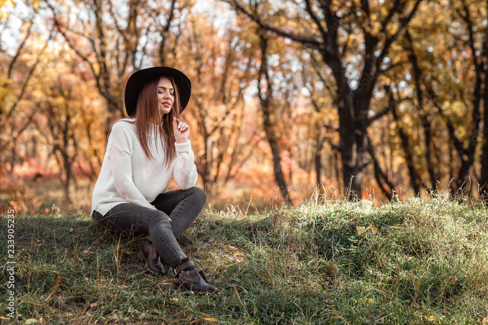 beautiful woman sitting on grass on sunny autumn day. beautiful woman sitting on grass on sunny autumn day.