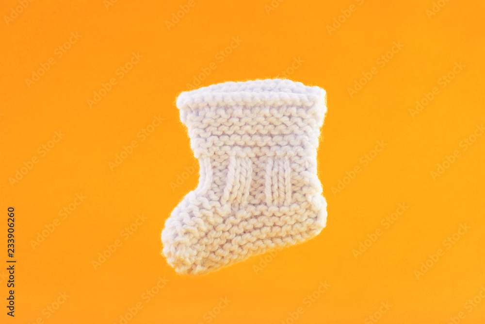 White baby sock on orange background White baby sock on orange background