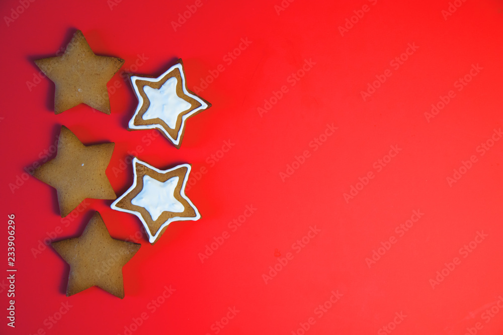 A row of three star cookies. Cookies tied a red ribbon. This fine handcrafted and painted by hand. Cookies in the shape of the star on red background.