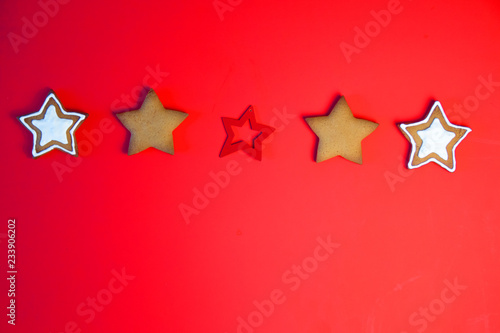 A row of three star cookies. Cookies tied a red ribbon. This fine handcrafted and painted by hand. Cookies in the shape of the star on red background.