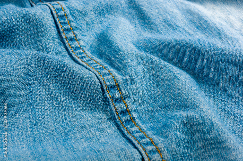 Blue washed faded jeans texture with seams Blue washed faded jeans texture with seams