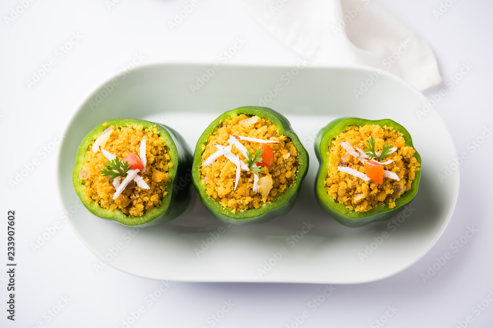 Stuffed capsicum or bharwa shimla mirchi is a popular Indian main course recipe. Served in a plate over moody background. Selective focus Stuffed capsicum or bharwa shimla mirchi is a popular Indian main course recipe. Served in a plate over moody background. Selective focus
