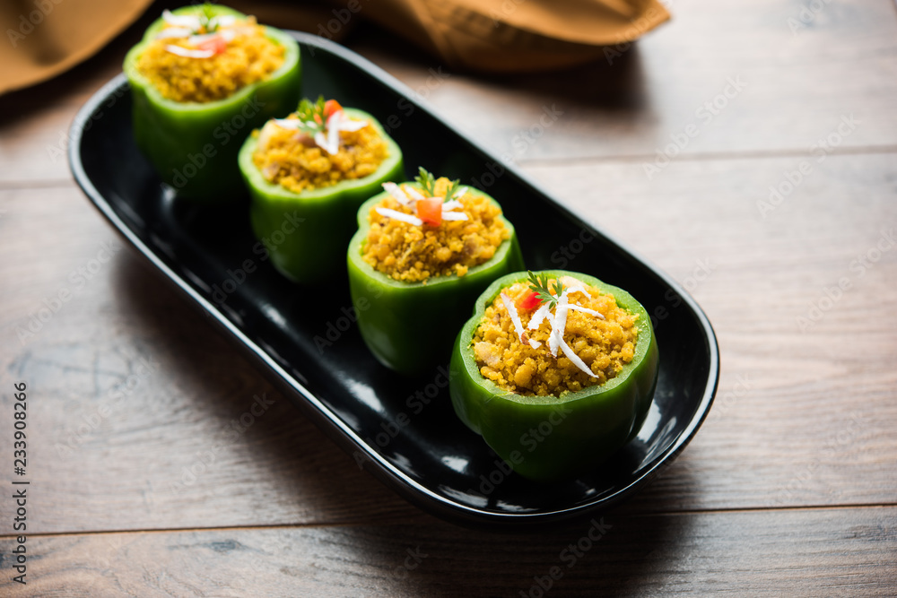 Stuffed capsicum or bharwa shimla mirchi is a popular Indian main course recipe. Served in a plate over moody background. Selective focus Stuffed capsicum or bharwa shimla mirchi is a popular Indian main course recipe. Served in a plate over moody background. Selective focus