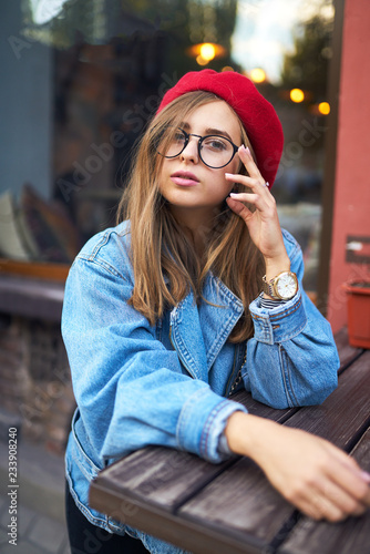 Summer sunny lifestyle fashion portrait of young stylish hipster woman walking on street,wearing cute trendy outfit with red hat ,smiling enjoy weekends. 