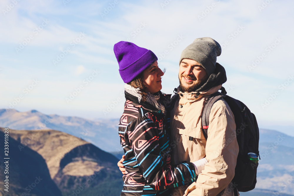 Beautiful couple in the mountains. Autumn. View from the mountain. Necking. Tourists in the hike Beautiful couple in the mountains. Autumn. View from the mountain. Necking. Tourists in the hike