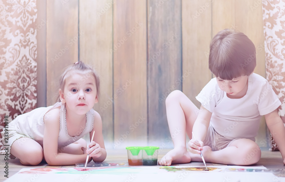 Little children paint on a large sheet of paper Little children paint on a large sheet of paper