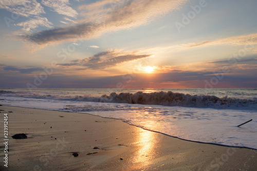Fototapeta Naklejka Na Ścianę i Meble -  Foamy wave at the sunset sandy beach