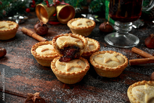 British Christmas mince pies with decoration, gifts, green tree branch on wooden rustic table