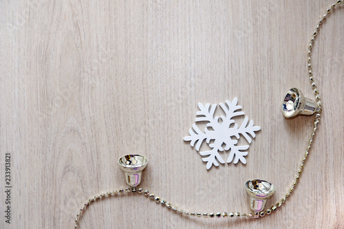 Christmas snowflake and bells on wooden background