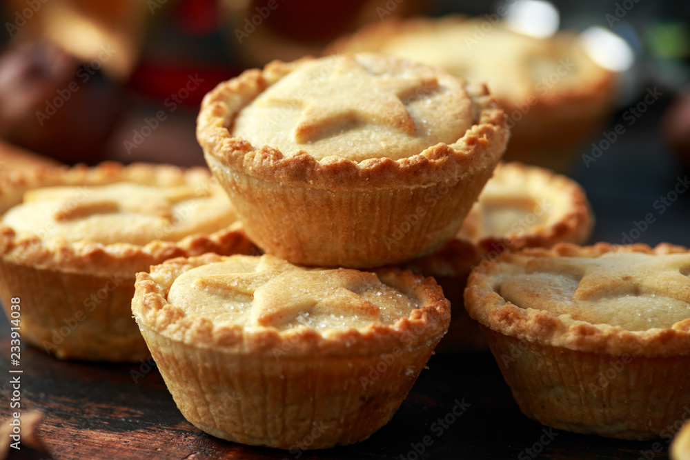 British Christmas mince pies with decoration, gifts, green tree branch on wooden rustic table