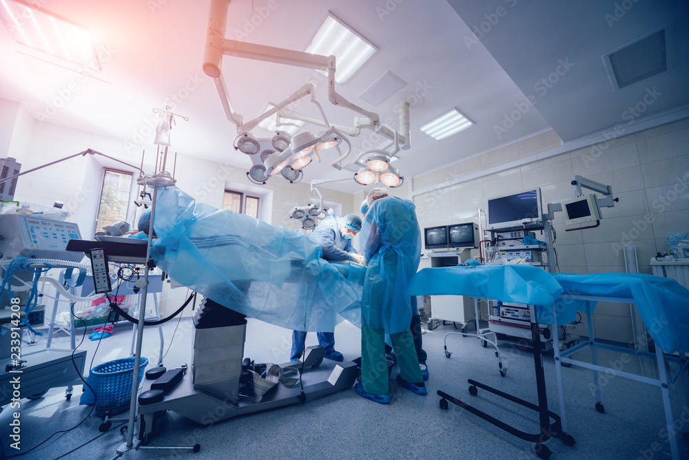 Process of trauma surgery operation. Group of surgeons in operating room with surgery equipment. Process of trauma surgery operation. Group of surgeons in operating room with surgery equipment.