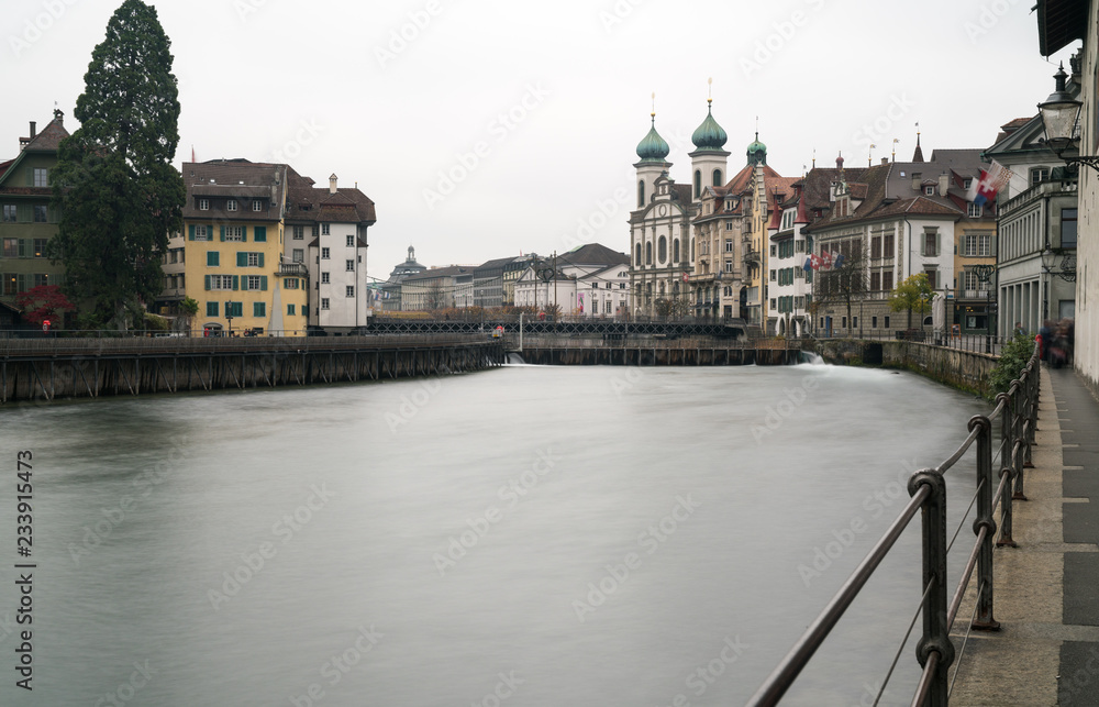Lucerne, LU / Switzerland - November 9, 2018: the famous Swiss city of Lucerne cityscape skyline and Jesuit church with the river Reuss panorama view long exposure