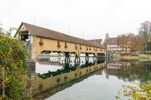 old covered wooden toll bridge over the river Rhine connecting the countries of Switzerland and Germany at Rheinau photo