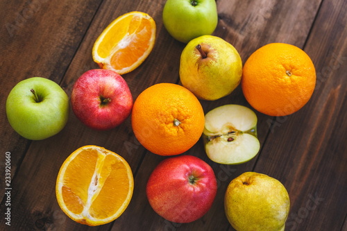 Different varieties of oranges  apples and pears on a wooden table