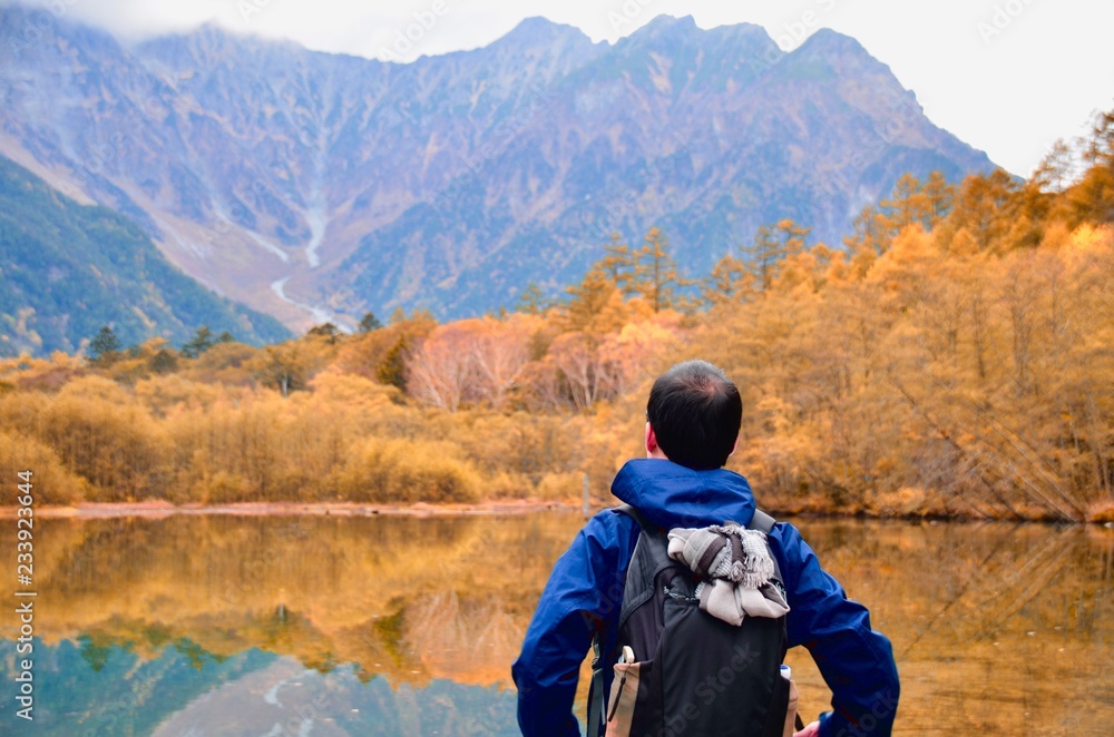 freedom man with stand near the lake side against natural autumn forest and mountains freedom man with stand near the lake side against natural autumn forest and mountains
