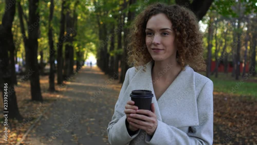 Business lady drinking coffee in the autumn Park. Woman in Park. Business lady drinking coffee in the autumn Park. Woman in Park.