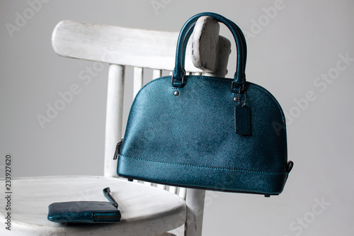 women leather bag and purse(dark green, blue, turquoise color) on a white wooden chair, advertising shooting bags, presentation bags, leather handbag (horizontally)