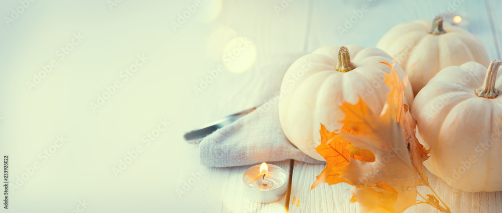 Thanksgiving background. Holiday scene. Wooden table, decorated with pumpkins, autumn leaves and candles. Wide screen