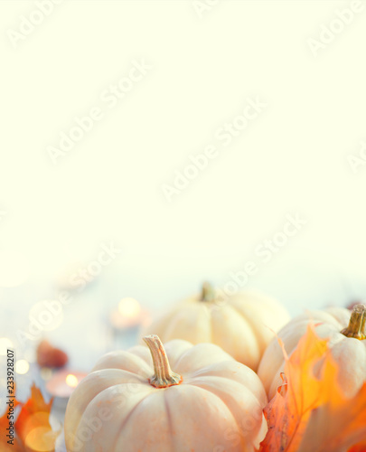 Thanksgiving background. Holiday scene. Wooden table, decorated with pumpkins, autumn leaves and candles. Vertical image