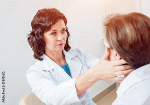 Neurological examination. The neurologist testing reflexes on a female patient using a hammer.