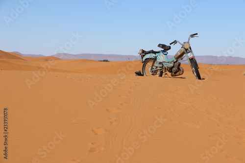 Motorcycle in the middle of the desert of Merzouga.