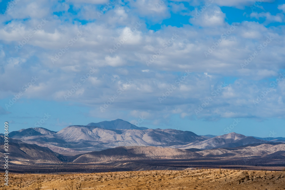 Cloudy blue sky over desert mountain landscape in California. Cloudy blue sky over desert mountain landscape in California.