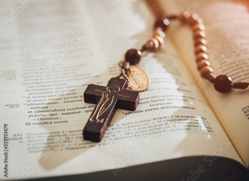 the wooden cross over opened bible on wooden table