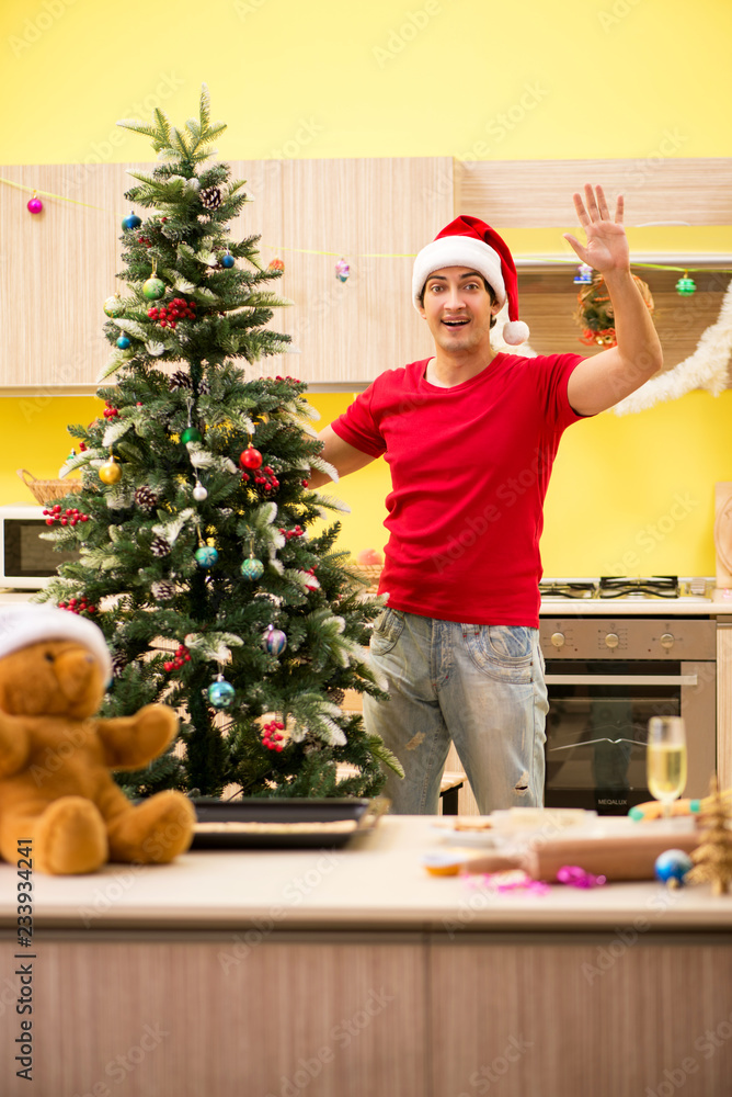 Young man celebrating Christmas in kitchen Young man celebrating Christmas in kitchen