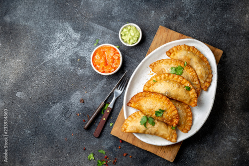 Latin American fried empanadas with tomato and avocado sauces. Top view photo