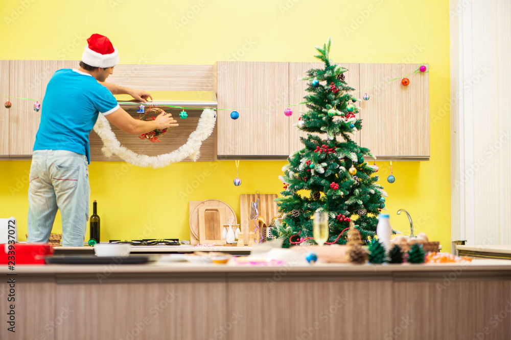 Young man celebrating Christmas in kitchen Young man celebrating Christmas in kitchen