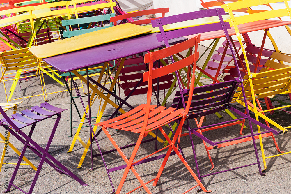 Multicolored outdoor chairs and tables dumped randomly