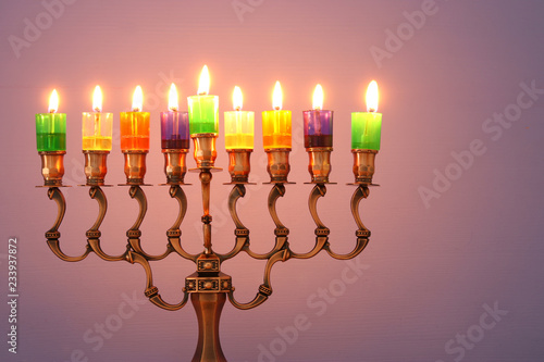 image of jewish holiday Hanukkah background with menorah (traditional candelabra) and colorful oil candles.